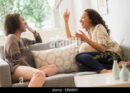 Donne che ridono rilassante sul divano Foto Stock