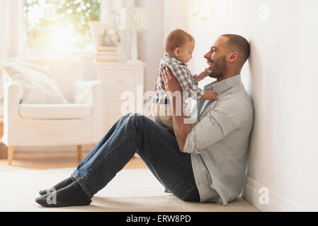 Padre giocando con il bambino figlio sul pavimento Foto Stock