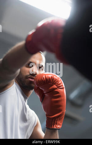 Ravvicinata di un uomo ispanico sacco da boxe in palestra Foto Stock