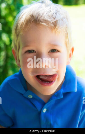 Ragazzo biondo sorridente con faccia sporca Foto Stock