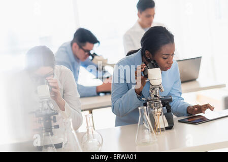 Gli scienziati utilizzano microscopi e tavoletta digitale nel laboratorio di ricerca Foto Stock