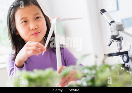Studente cinese di esaminare il modello di turbina eolica nel laboratorio di scienze Foto Stock