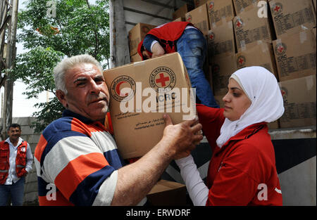 Damasco. 8 Giugno, 2015. Un abitante riceve aiuti materiali nel sobborgo di Moadamiyeh nella periferia di Damasco Capitale della Siria il 8 giugno 2015. Il Syrian Arab Red Crescent (SARC) eroga convogli di aiuti umanitari Lunedì alle persone colpite in Moadamiyeh che ha vissuto le battaglie e prolungato assedio. Credito: Ammar/Xinhua/Alamy Live News Foto Stock