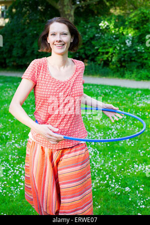 La donna nel parco con hula hoop Foto Stock