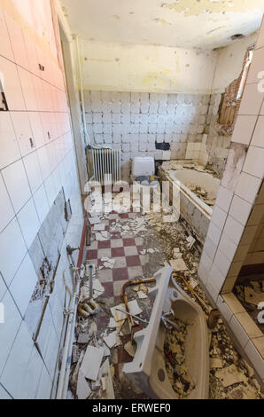 Vista interna di un bagno abbandonata con i detriti Foto Stock