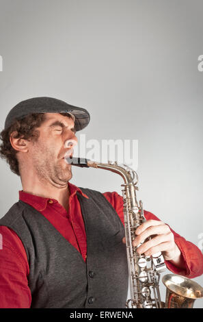 Uomo bruttissimo si lamenta il sassofono mentre vestito come un beatnik Foto Stock