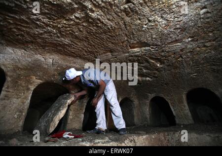 Jenin, West Bank città di Jenin. 8 Giugno, 2015. Un lavoratore palestinese nei servizi archeologici scava dentro un cimitero archeologico di epoca romana, in Cisgiordania città di Jenin, il 8 giugno 2015. La polizia palestinese e il Ministero del Turismo e antichità scoperto mercoledì scorso un cimitero archeologici risalenti all'epoca romana, durante i lavori di dragaggio in Ya'bad villaggio vicino alla Cisgiordania città di Jenin, secondo i funzionari palestinesi. © Ayman Nobani/Xinhua/Alamy Live News Foto Stock