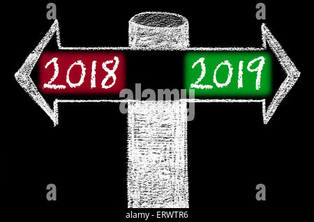 Frecce opposte con l'anno 2018 rispetto all'anno 2019. Disegno a mano con un gessetto sulla lavagna. Scelta immagine concettuale Foto Stock