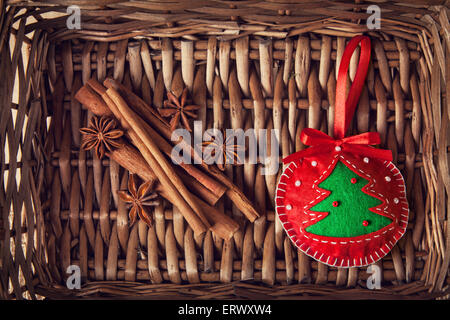 Natale fatti a mano giocattolo rossa con albero dal feltro, cannella e anice stellato in marrone twiggen cestello Foto Stock