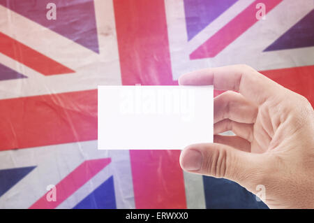 Uomo caucasico Holding Blank Business Card contro il Regno Unito di Gran Bretagna Bandiera, Retro Vintage rustico effetto di tono Foto Stock