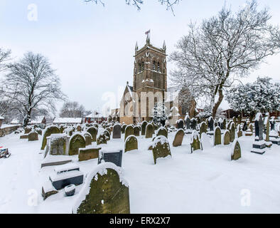 Un villaggio chiesa presi in inverno con neve sulla terra e sul campanile della chiesa Foto Stock