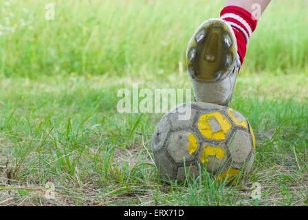 Soccer sul vecchio e brutto campo con sfera squallido closeup. Foto Stock