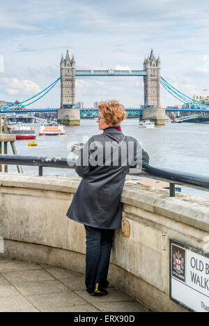 Femmina su Old Billingsgate a piedi con il Tower Bridge in background. Foto Stock