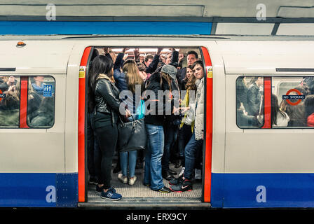 Tubo treno pieno di persone sulla metropolitana di Londra - porte aperte Foto Stock