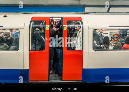 Tubo treno pieno di persone sulla metropolitana di Londra - chiusura porte Foto Stock