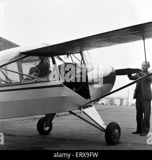 La signora Diana Freeman da Headcorn, Kent spiega i controlli della sua austera aeromobile wile i suoi figli Jamie, di età compresa tra i 6 e Elizabeth, di età compresa tra i 2, guarda su. La famiglia, tra cui marito Cristoforo e cane ben luppolata, andò a Rochester Aerodrome oggi tuttavia nebbia fatta volare impossibile. Il 22 novembre 1964. Foto Stock