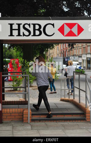 Una donna entra in un high street branch di HSBC in Bristol. Foto Stock