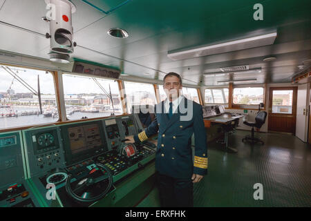 Kiel, Germania. 09 Giugno, 2015. George Ciortan, capitano del 'MS Deutschland, ' pone al timone in Kiel, Germania, 09 giugno 2015. La nave, reso famoso dalla serie televisiva "come Traumschiff" (lit. Il sogno di nave), decolla oggi per la sua ultima crociera viaggio sotto comando tedesco. Credito: dpa picture alliance/Alamy Live News Foto Stock