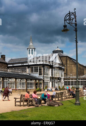 Regno Unito, Inghilterra, Derbyshire, Buxton, Pavilion Gardens, visitatori sat in Sun al di fuori del padiglione Foto Stock