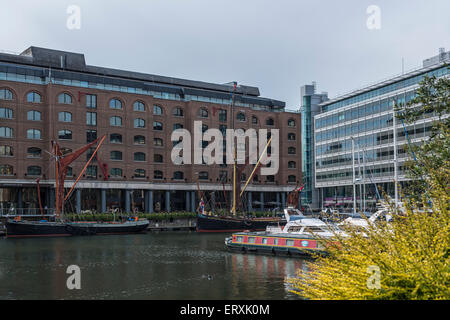 International House e il Tower Bridge House attraverso St Katherine Docks di Londra con barche in primo piano Foto Stock