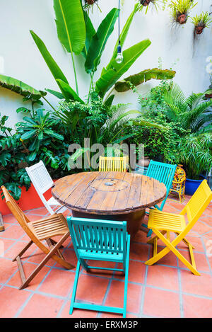 Vivacemente colorato funky con sedie in legno e tavolo in giardino Foto Stock