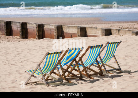 Vuoto di sedie a sdraio e groyne a Bournemouth Beach nel giugno Foto Stock