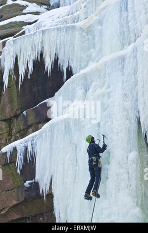 Ice Climber scalare una cascata ghiacciata Kinder rovina su Kinder Scout Derbyshire Peak District Inghilterra UK GB EU Europe Foto Stock