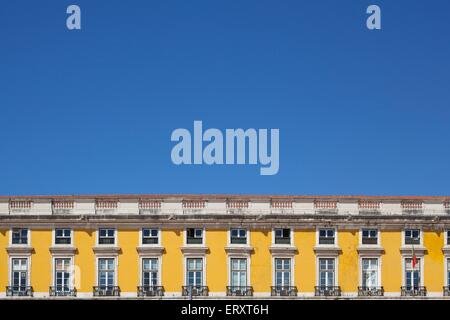 Gli edifici colorati in Praca de Comercio di Lisbona contro un luminoso cielo blu in estate Foto Stock