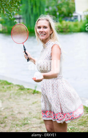 Donna bionda la riproduzione di badminton in un parco Foto Stock