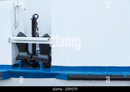 Un ancoraggio nero a bordo di un bianco e blu barca Foto Stock