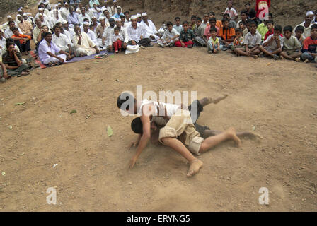 Due lottatori di impegnarsi in una concorrenza wresting durante una fiera locale al villaggio Dimba ; district Pune ; Maharashtra ; India Foto Stock