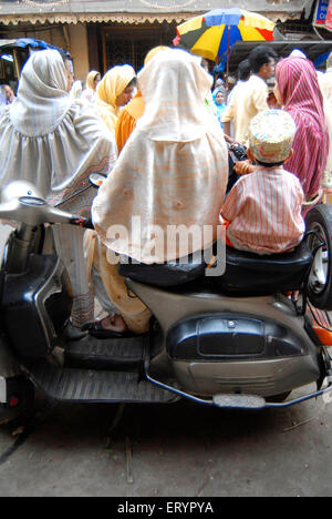 Dawoodi Bohra donna musulmana e bambino seduto su uno scooter ; Mumbai Bombay ; Maharashtra ; India Foto Stock