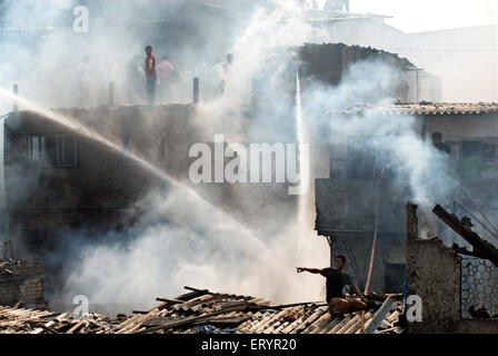 Abitatori spegnimento incendio in baraccopoli Behrampada ; Bandra ; Mumbai Bombay ; Maharashtra ; India residenti 18 Giugno 2009 Foto Stock