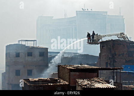 Firefighter spegnimento incendio in baraccopoli Behrampada ; Bandra ; Mumbai Bombay ; Maharashtra ; India 18 Giugno 2009 Foto Stock