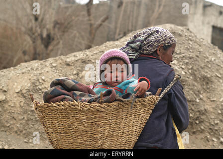 Madre che porta il figlio nel cesto di canna , Leh , Ladakh , Jammu e Kashmir , India , Asia Foto Stock