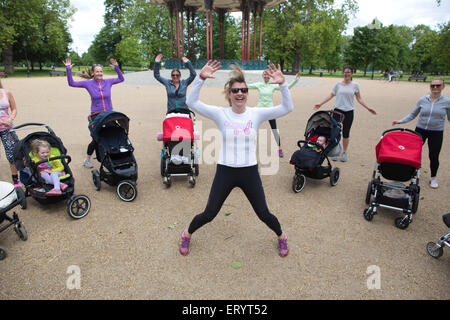 La Madre ha tenuto un esercizio di classe con baby e bimbo a nei loro passeggini in un parco in London, England, Regno Unito Foto Stock