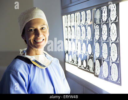 Ritratto di chirurgo sorridente riesaminando le scansioni MRI Foto Stock