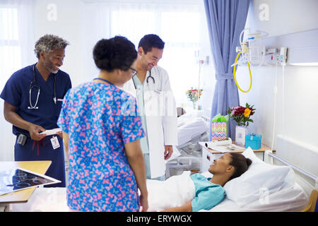 I medici facendo turni e parlare con il paziente in ospedale Foto Stock