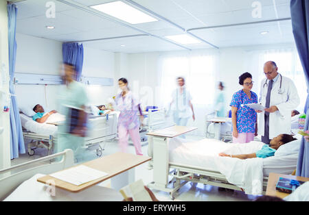 I medici e gli infermieri facendo turni nella stanza di ospedale Foto Stock