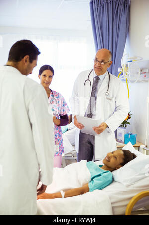 Medici e infermieri facendo turni nella stanza di ospedale Foto Stock