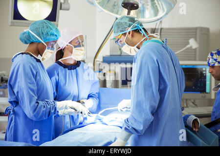 I chirurghi di eseguire un intervento chirurgico in sala operatoria Foto Stock
