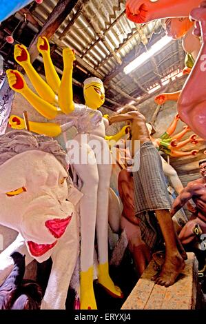 Clay modeller lavorare sulla immagine della dea Durga ; patrimonio Kumartuli villaggio artigianale di Calcutta ; Bengala Occidentale ; India Foto Stock