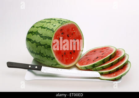 Frutti ; Water melon latino Citrullus lanatus fette e coltello su un vassoio Foto Stock