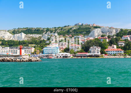 Il paesaggio costiero di Balchik cittadina. Ingresso alla porta, rosso faro sul molo. Costa del Mar Nero, regione di Varna, Bu Foto Stock