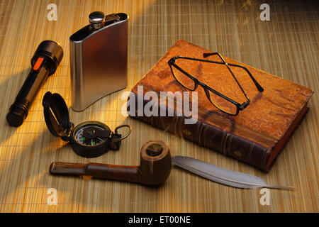 Esploratore, vecchio libro, bussola, bottiglia, tubo, torcia, occhiali, Foto Stock