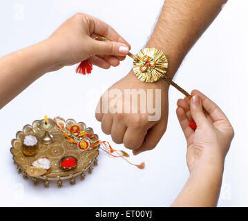 Raksha Bandhan festival ; sorella rakhi legatura sul fratello la mano ; Bombay ora Mumbai ; Maharashtra ; India Foto Stock