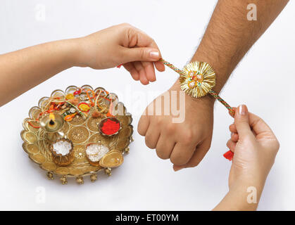 Raksha Bandhan festival ; sorella rakhi legatura sul fratello la mano ; Bombay ora Mumbai ; Maharashtra ; India Foto Stock