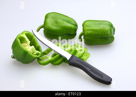 Coltello affilato con impugnatura nera con fette di peperoni verdi latino Capsicum annuum ; Insalata ; India Foto Stock