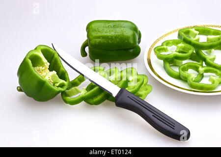 Coltello con fette di peperoni verdi latino Capsicum annuum su una piastra ; Insalata ; India Foto Stock