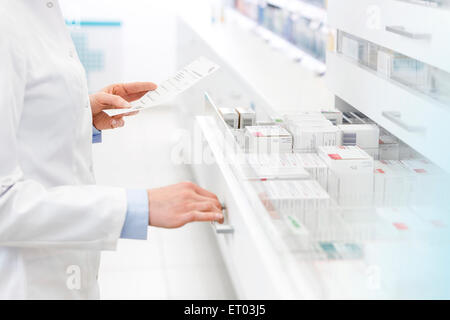 Il farmacista prescrizione di riempimento in farmacia Foto Stock